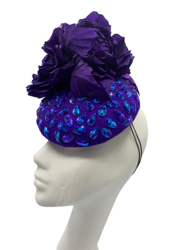 Stunning purple felt base headpiece with irridescent blue embelished detail and finished with stunning hand made silk flower details.